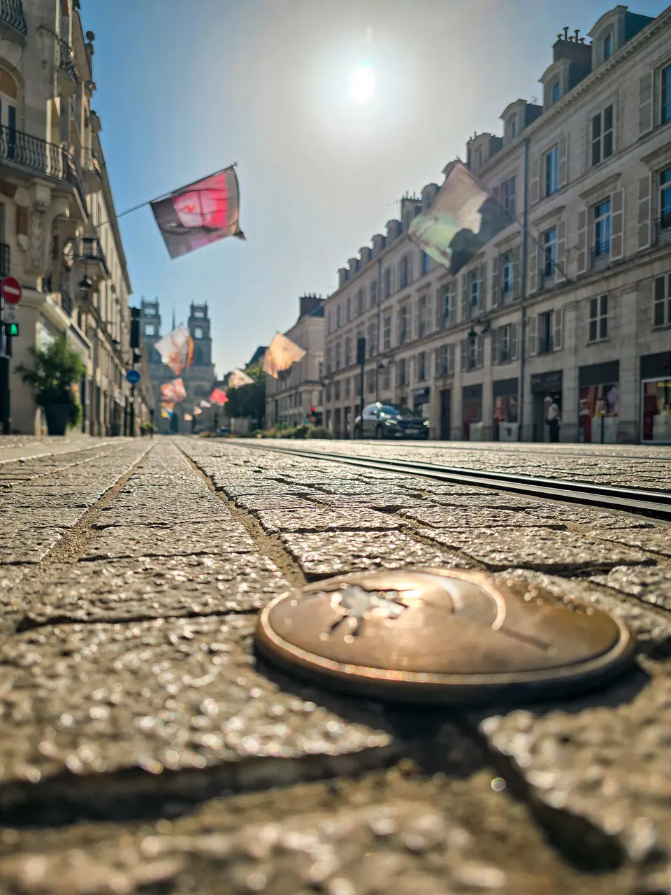 Une pièce de monnaie posée sur les pavés d'une rue ensoleillée