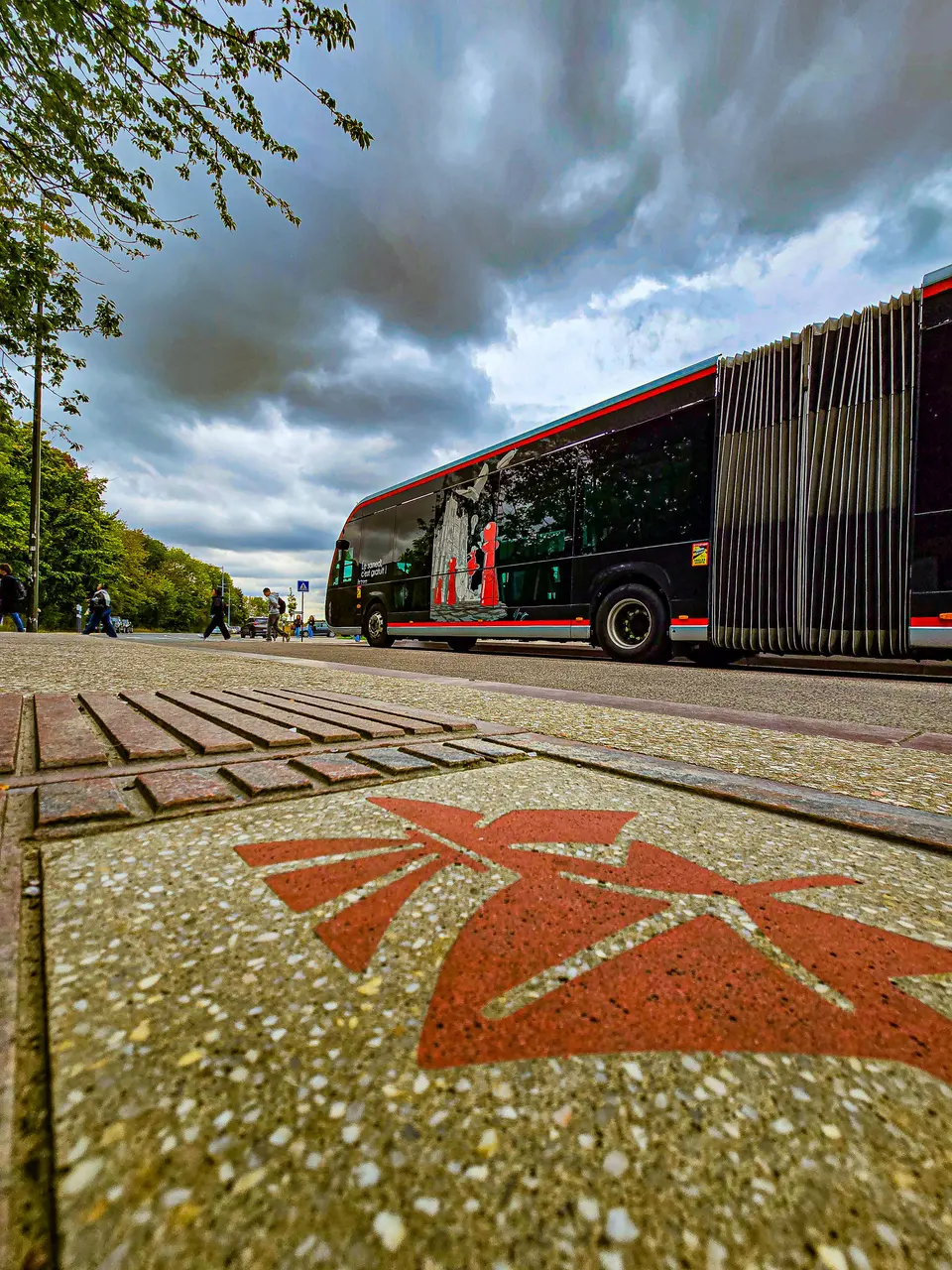 Un bus aux couleurs de la ville sous un ciel d'orage