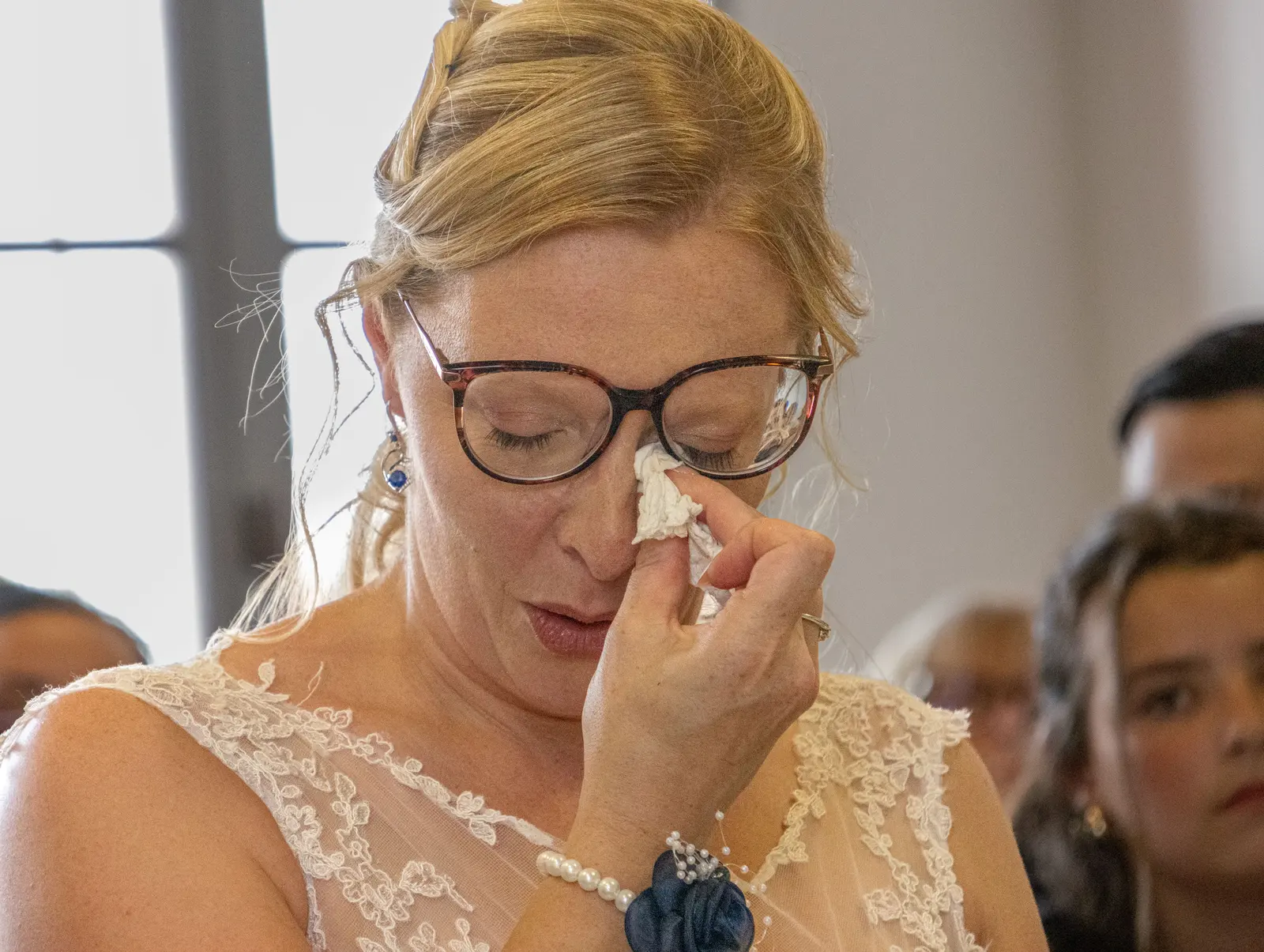 Une mariée émue essuie une larme pendant la cérémonie